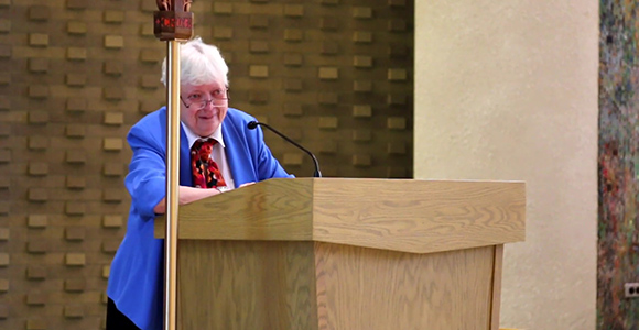 Sister Mary Ann Flannery accepting her award at podium in mater dei chapel.