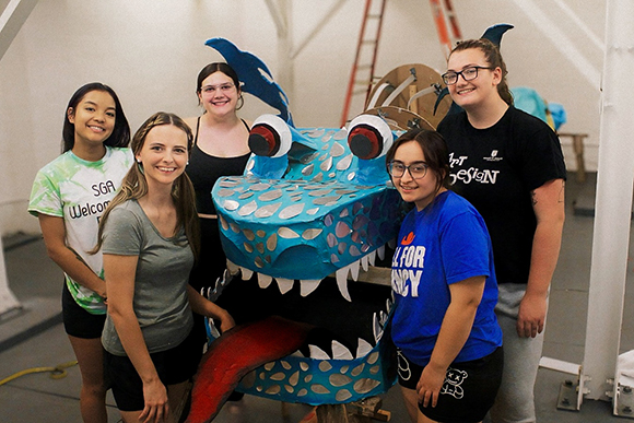 group standing with sustainable dragon sculpture