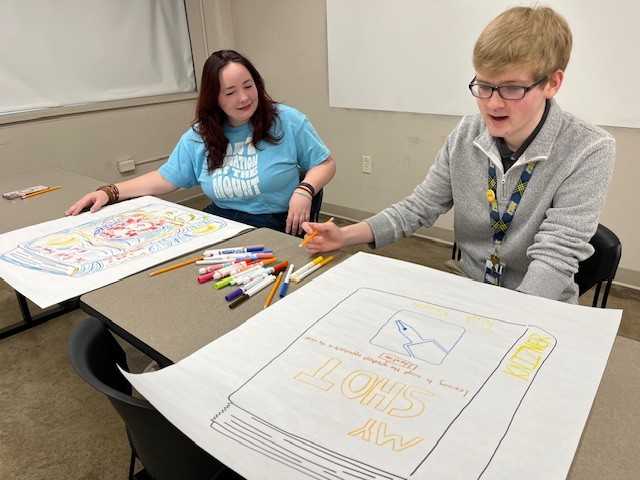Joey Knizner and Ella Jane Kuhnell creating memoir covers along with high school seniors during a recent scholarship event.