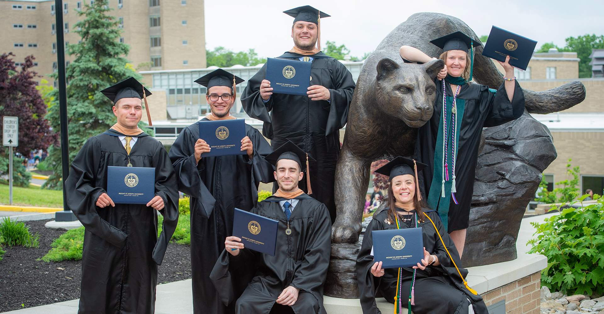 graduates by lions statue