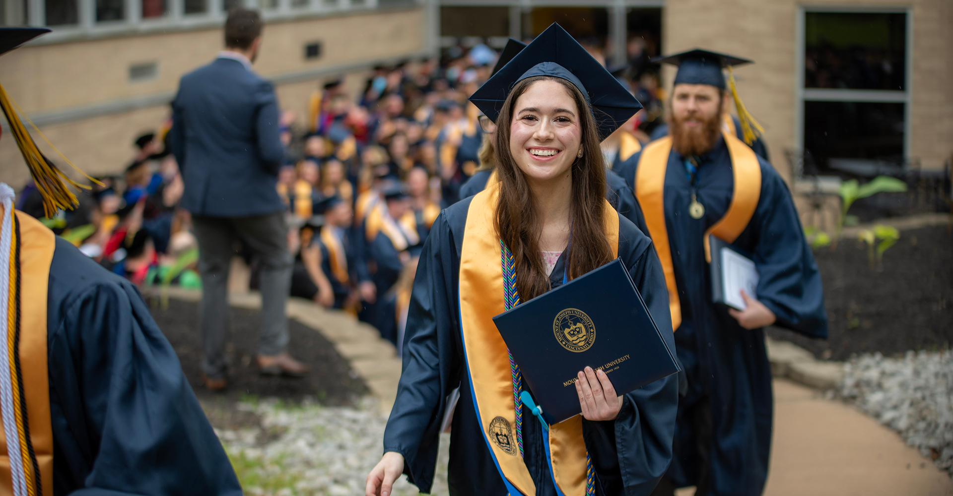 Female graduate receiving diploma from President Williams