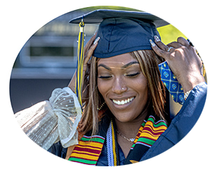female graduate smiling and holding cap.