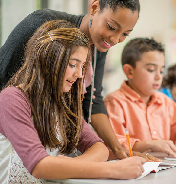 teacher with student in classroom