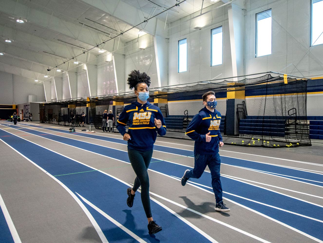 Students running on the Centennial Field House track.