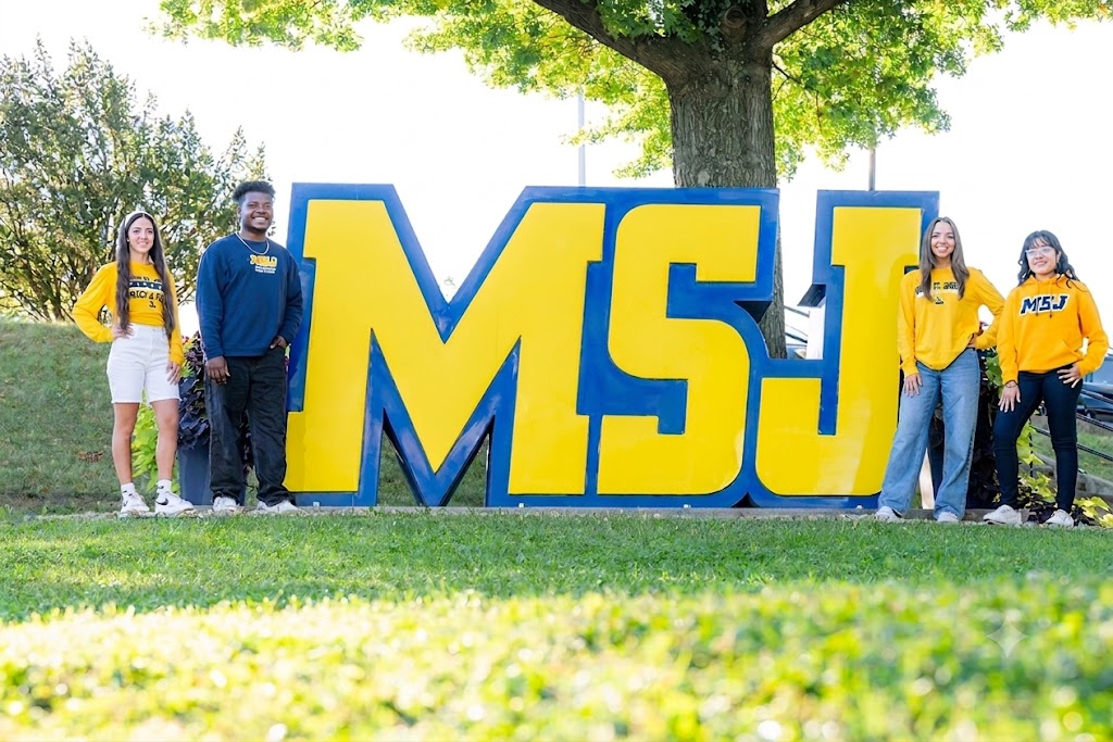 students standing next to campus icon