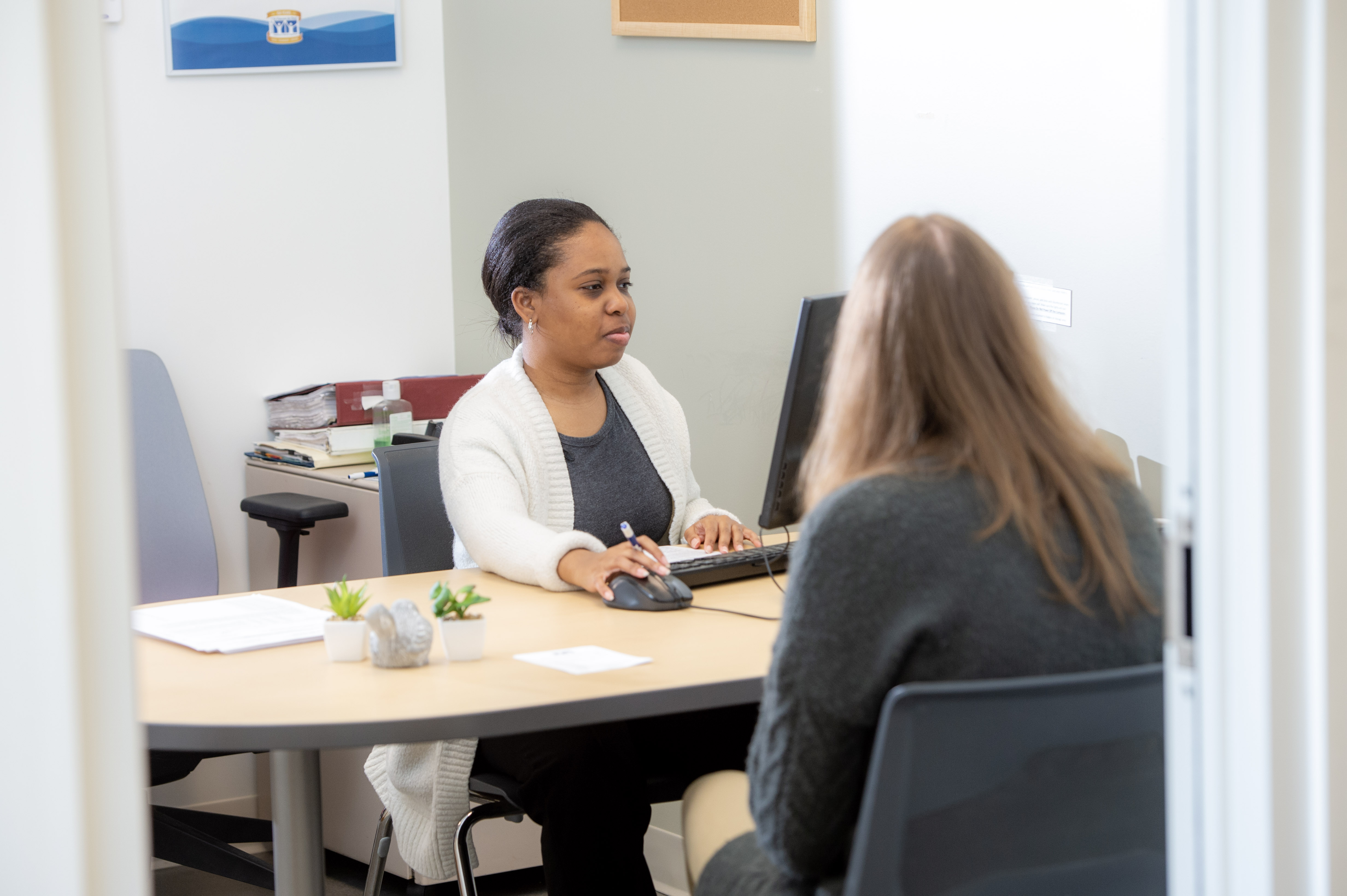 social worker sitting at desk helping a client