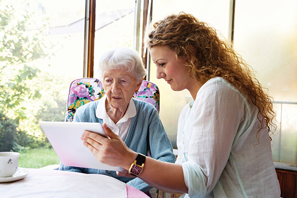 social worker helping elderly woman read 