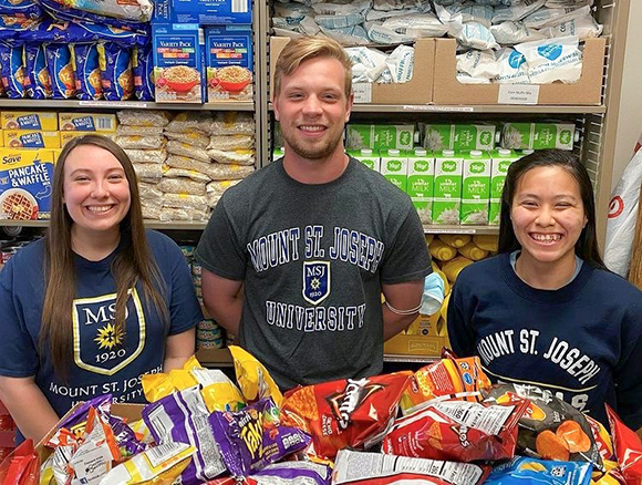 students standing in food pantry smiling