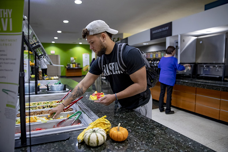 guy scooping lettuce on plate